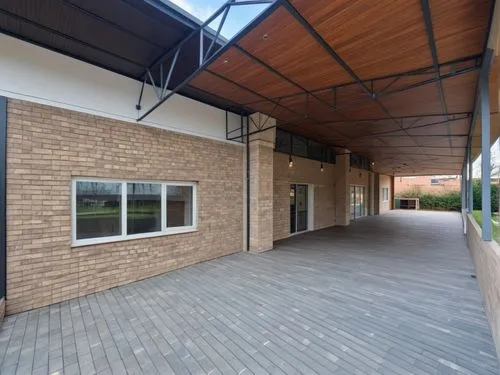 The wall is made of beige stone blocks, up to the windows, then the walls are covered with beige plaster. WINDOWS WITH white FRAMES and an entrance door, the roof is structurally COVERED WITH TRANSPAR