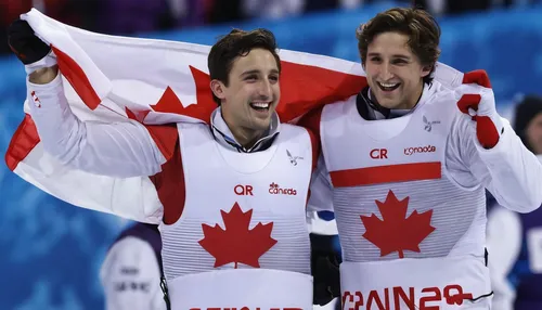 Canada's Alex Bilodeau, left, celebrates with his brother Frederic after winning the gold medal in the men's moguls final at the Rosa Khutor Extreme Park at the 2014 Winter Olympics, Monday, Feb. 10, 