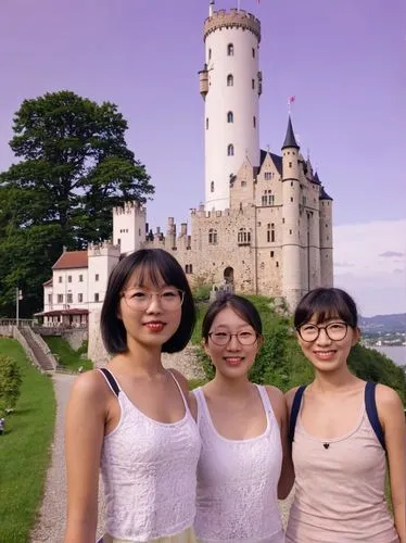 Asian tourist girls in front of Lichtenstein Castle.,two girls are standing next to each other in front of an castle,eurasians,asiaticas,french tourists,cultural tourism,neuschwanstein castle,quartet 