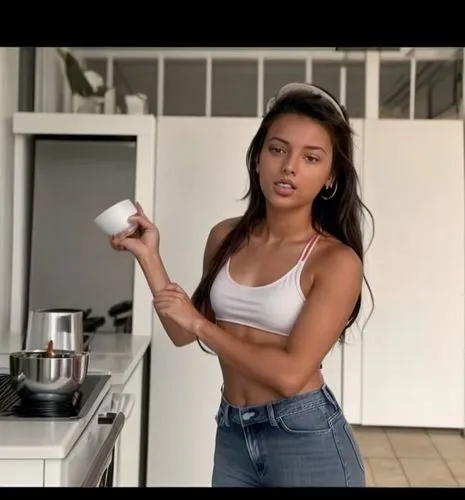 A sexy 19-year-old girl.  Standing in a simple Mediterranean kitchen making coffee.  She is dizzy from the smell of coffee listening to music and singing loudly.  She wears jeans and a tank top.  She 