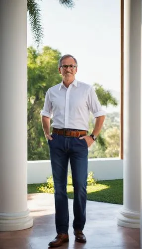 Middle-aged, male, architect, standing, confident posture, black-rimmed glasses, short brown hair, light stubble, white shirt, rolled-up sleeves, dark blue jeans, leather belt, black dress shoes, hold