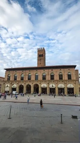 an old brick building on the corner of a plaza,ferrara,faenza,fossano,piazza san marc,piacenza,arezzo