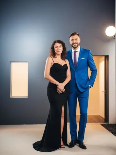 Mr. and Mrs. Maurer in front of their German single-family home bungalow in the city.,a man and woman posing in front of some lights,social,pre-wedding photo shoot,nav,beautiful couple,wedding couple,