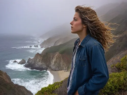 Big Sur coastline, dramatic cliffside, strong winds, waves crashing against rocks, spray misting into air, rugged terrain, rocky shores, lone figure in distance, young adult, casual outfit, wind-blown