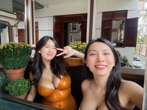 boobs window,two woman in orange body paint standing next to each other,bangkok,bkk,hanoi,xuyen,hua hin,seminyak