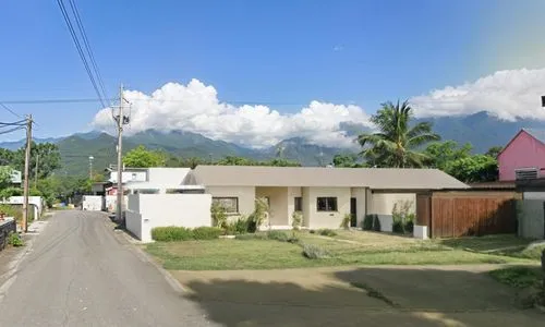 a white building and trees near the road,merapi,ovalau,kosrae,ranau,fatialofa,wamena