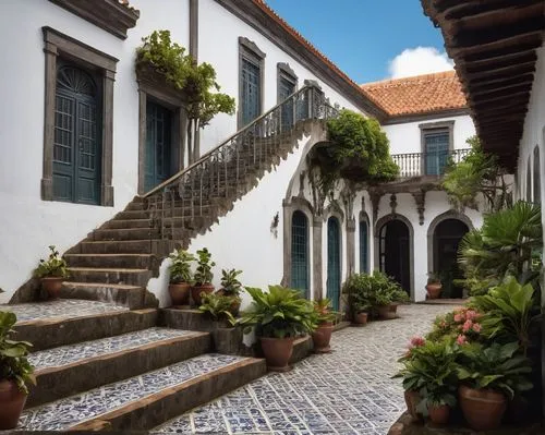 Azores architecture, Portuguese colonial style, whitewashed walls, terra cotta roofs, ornate wooden doors, colorful ceramic tiles, intricate stone carvings, grand staircase, spacious interior courtyar