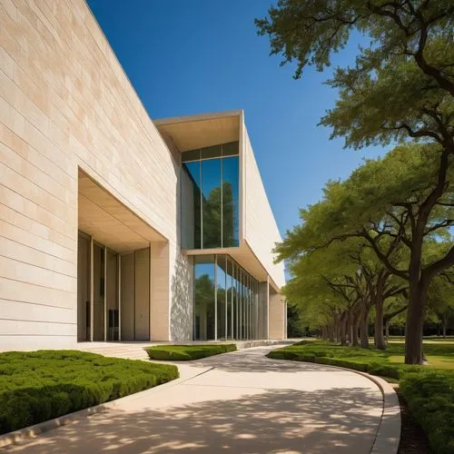 Kimbell Art Museum, modern architectural style, white limestone exterior, curved lines, grand entrance, large windows, natural light, open courtyard, sculpture garden, walking path, surrounded by tree