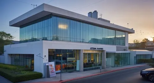 As the camera zooms in on the exterior façade, a man in a crisp orange hat sits at the edge of a rickety glass podium, his eyes locked as the viewer gazes out at the bustling intersection. The exterio