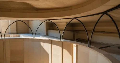 beige surface is limestone. arches are black steel members,goetheanum,blavatnik,circular staircase,utzon,clerestory,seidler,antinori,vaulted ceiling,triforium,acconci,thomas jefferson memorial,vaulted