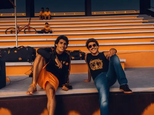 two latin brothers ,two male s smiling next to some bleachers,aterciopelados,modelos,lindos,fabulosos,legian,tribunes,acapulco,paraguayans,salgueiros,photo session at night,grandstand,hermanos,grandst