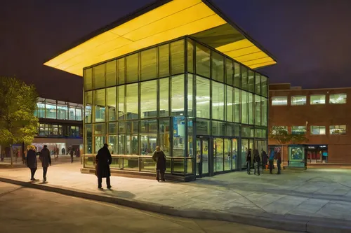 Write a suspenseful scene set at the John Olver Transit Center at nighttime.,music conservatory,performing arts center,northeastern,kettunen center,new building,glass facade,school design,student info