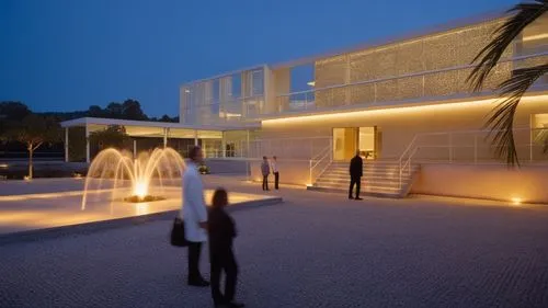 minimum light 
,people are walking around outside a building with a fountain,amanresorts,champalimaud,therme,futuristic art museum,quadriennale,glass facade,glass wall,chancellery,oberoi,modern archit