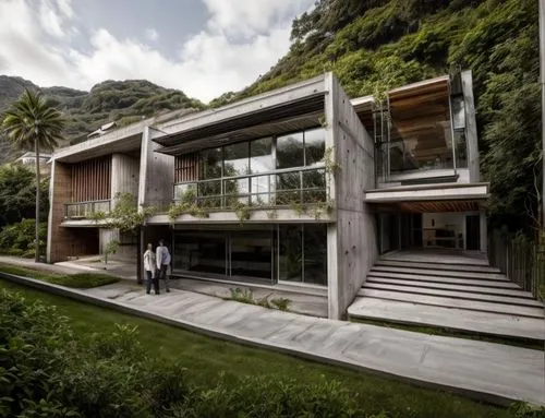 Diseño exterior de una residencia estilo mínimalista, con muros de concreto color blanco, perfiles con canal de acero en losa, ventanal de cristal en la parte superior del acceso, ventana en el estudi