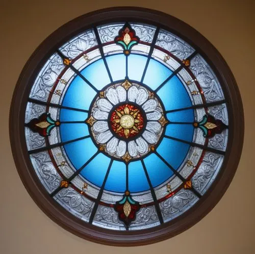 an antique stained glass window hangs above the bed,round window,stained glass window,stained glass,church window,leaded glass window,stained glass windows