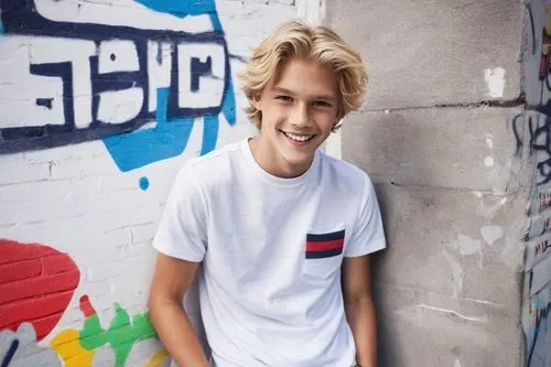 Tommy Hilfiger model, young boy, Shota, blonde hair, blue eyes, freckles, smiling face, casual wear, white T-shirt, Tommy Hilfiger jeans, sneakers, relaxed posture, hands in pocket, leaning against a 