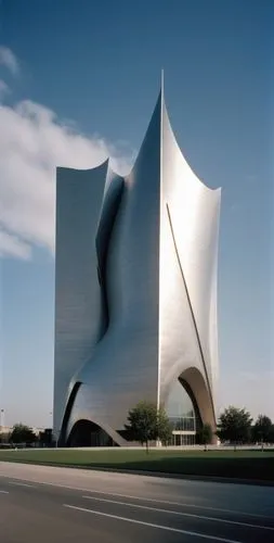 a modern building with curving lines on the facade and its architecture against the blue sky,disney hall,walt disney concert hall,calatrava,libeskind,gehry,futuristic art museum,Photography,Documentar