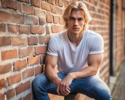 Handsome Andreas, young adult male, blond hair, blue eyes, fit physique, casual wear, denim jeans, white T-shirt, sneakers, relaxed posture, leaning against, brick wall, urban setting, afternoon sunli