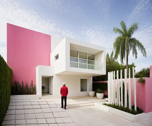 man walking in front of a colorful, modern building,dreamhouse,tropical house,frame house,prefab,modern house,piramal