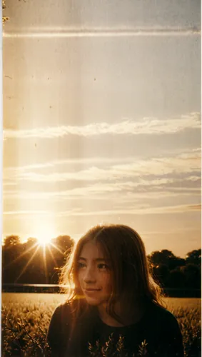 a girl stands in an open field with the sun in her eyes,ektachrome,lens flare,light leak paper,kodachrome,sunray,sunbeams