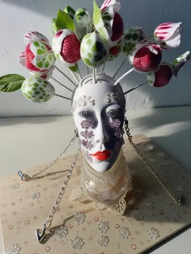 a mask with flowers in it is on a display,pagliacci,porcelaine,venetian mask,pierrot,comedy tragedy masks,creepy clown,Photography,General,Realistic