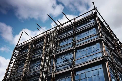 Industrial matrix-inspired building, Northampton, UK, modern architectural design, intricate ironmongery details, metallic structure, exposed pipes, steel beams, urban landscape, cloudy sky, dramatic 