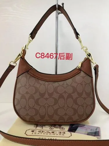 the brown coach handbag is on top of a purse and a card,carpetbag,taobao,carryall,cagw,cag,bag