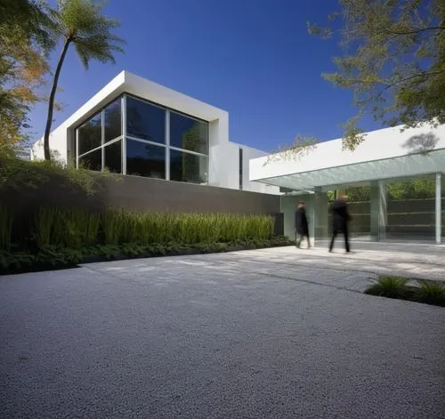 Diseño exterior de una casa moderna estilo minimalista combinando muros de color blanco con muros de tabique aparente, herrería de aluminio con cristal, fotografía hiperrealista, fotografía arquitectó