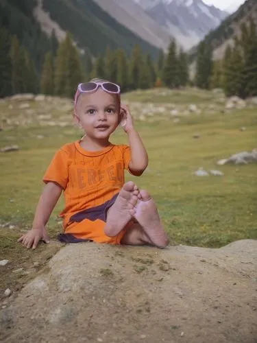 young toddler sitting on ground wearing sunglasses in field,nuristan,toddler in the park,kinnaur,naran,sangla,rohtang