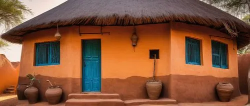 African architectural style, mud huts, thatched roofs, earthy tones, natural materials, wooden doors, intricately carved, geometric patterns, vibrant colors, ornate details, traditional ornaments, cla