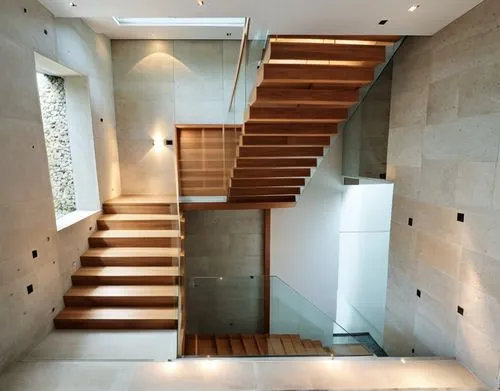 Tadao ando style beautiful staircase with teak wooden steps and elegant raining with light coming through a beautiful grid glass artic window wall on the side but solid stone wall at the back. The sta