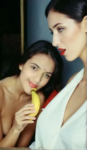 two women posing for the camera and one holding a banana,bananarama,woman eating apple,jogbra,modelos,mirifica,video scene