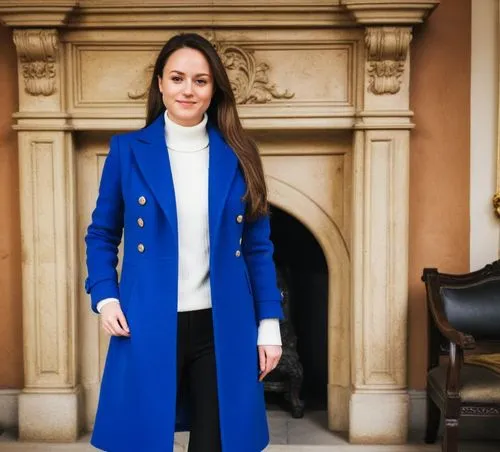 Wearing a royal coat ,a woman wearing black pants standing next to a fireplace,menswear for women,woman in menswear,teodorescu,stefanik,abdullayeva,navy suit