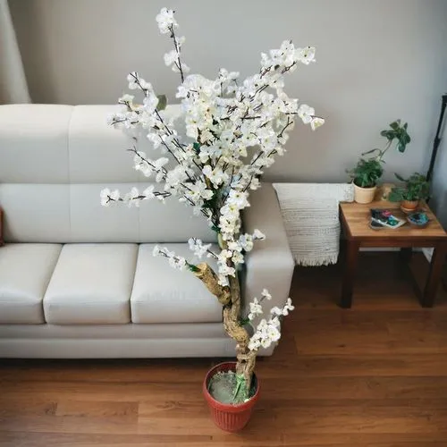 House Corner next to the couch on floor,ikebana,a sprig of white lilac,white flower cherry,flower arrangement lying,flower arrangement,flower vase,floral arrangement,white blossom,white lilac,indoor p