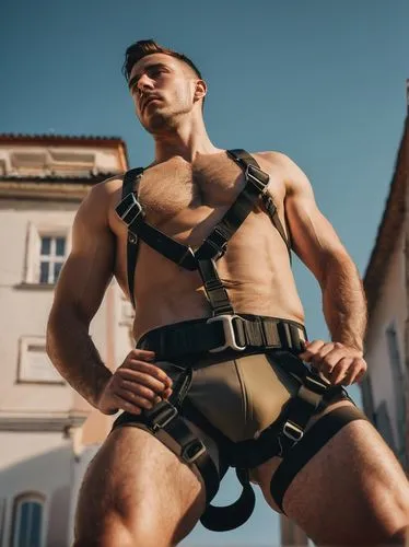 A 30 years old fit austrian man with a harness on his chest, jockstrap, view from below ,climbing harness,harness,leatherman,harnessed,folsom,harnesses,lederhosen,goncharov,musclebound,suspender,strap