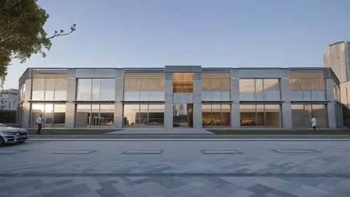 an artistic building sits in a park with two men walking by,athens art school,bocconi,fondazione,associati,moneo,assay office,glass facade,technion,music conservatory,ludwig erhard haus,modern buildin