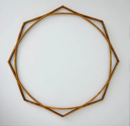 A frame made of wood against a white background,this piece of art has three smaller pieces of wood in the middle of it,circle shape frame,openwork frame,copper frame,bamboo frame,trivet,heart shape fr