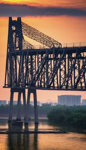 Describe the magnificent Tangshan Railway Bridge at sunrise.,aerial lift bridge,tangshan railway bridge,railroad bridge,cantilever bridge,transporter bridge,memorial bridge,truss bridge,south carolina