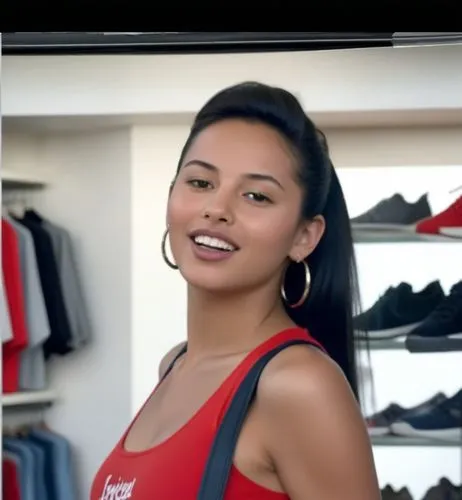 A surprise full body paparazzi photo.  The Moroccan girl with black hair gathered in a high ponytail is in a clothing store with shelves and hangers of brand name clothes in the background.  She wears