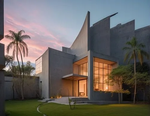 As the sun sets outside, a modern house looms majestically against the backdrop of a mesmerizing array of modern buildings. The walls are adorned with clean lines, while concrete elements add depth an