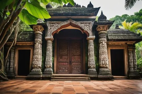 Ancient Sri Lankan architecture, intricately carved stone temple, grandiose entrance gate, ornate wooden doors, vibrant tile work, lush greenery surrounding, tropical trees with large leaves, bright s