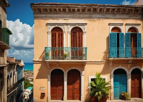 Haitian architecture, colorful buildings, wooden shutters, balconies with ornate ironwork, vibrant tropical flowers, palm trees, sunny day, bright blue sky, white puffy clouds, narrow cobblestone stre