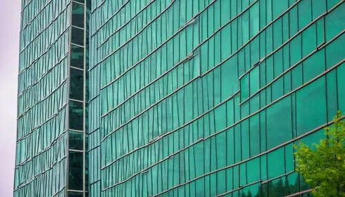 Modern architectural building, Vancouver BC, Canada, rainy day, cloudy sky, glass facade, steel structure, geometric shape, green roof, urban cityscape, busy streets, people walking, reflection in win