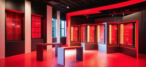 tony's chocolonely pop-up store design, the walls and floor are red. The ceiling is black. On the right wall, there is a black LED display in a zigzag shape. There is a red glossy table in front of th