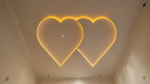 Gypsum decor in the ceiling of a room with hidden lighting, real decor,this is a very large room with hearts hanging on the ceiling,wall lamp,wall light,foscarini,heart shape frame,wire light,neon val