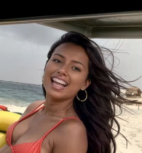 She sits on an inflatable banana towed with a boat in the Red Sea.  She wears a green and orange bikini.  Her hair is blowing in the wind and she is laughing.,rajakumari,azilah,mugdha,vrih,eritrean,ta