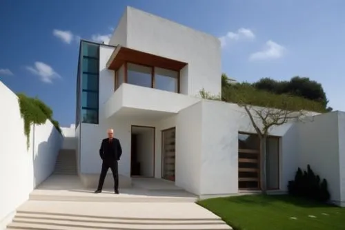 Diseño exterior de una casa estilo mínimalista, ubicada en un ambiente urbano, con el uso de colores vibrantes en datalles del marco de la ventana y celosía del patio de servicio, el resto en color bl