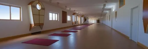 a hallway with several yoga mats in front of a window,gymnastics room,hallway space,corridor,vinyasa,gymnast hall,dojo,kelsang,eurythmy,corridors,fitness room,neurorehabilitation,vipassana,gymnasiums,