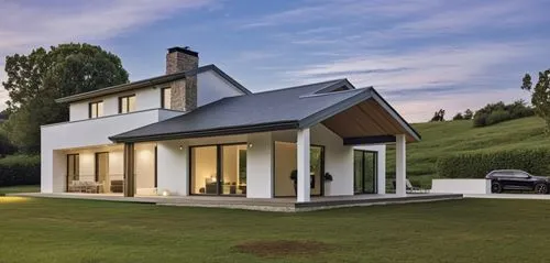 A modern, minimalist white house with clean lines and a few stone accents on the façade. The porch features white beams, complementing the sleek, minimalist design. The house is slightly elevated abov