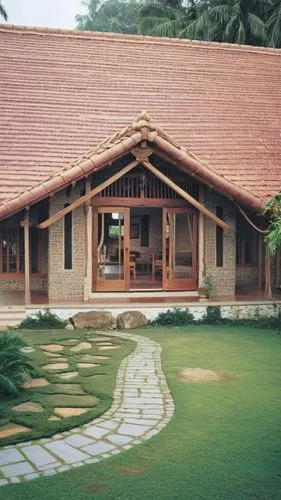 a symmetrical pitched roof kerala house, central entance with main door, either sides big glazed window, with front portion a pitched roof and either side higher roof pitched.  roof with mangalore til